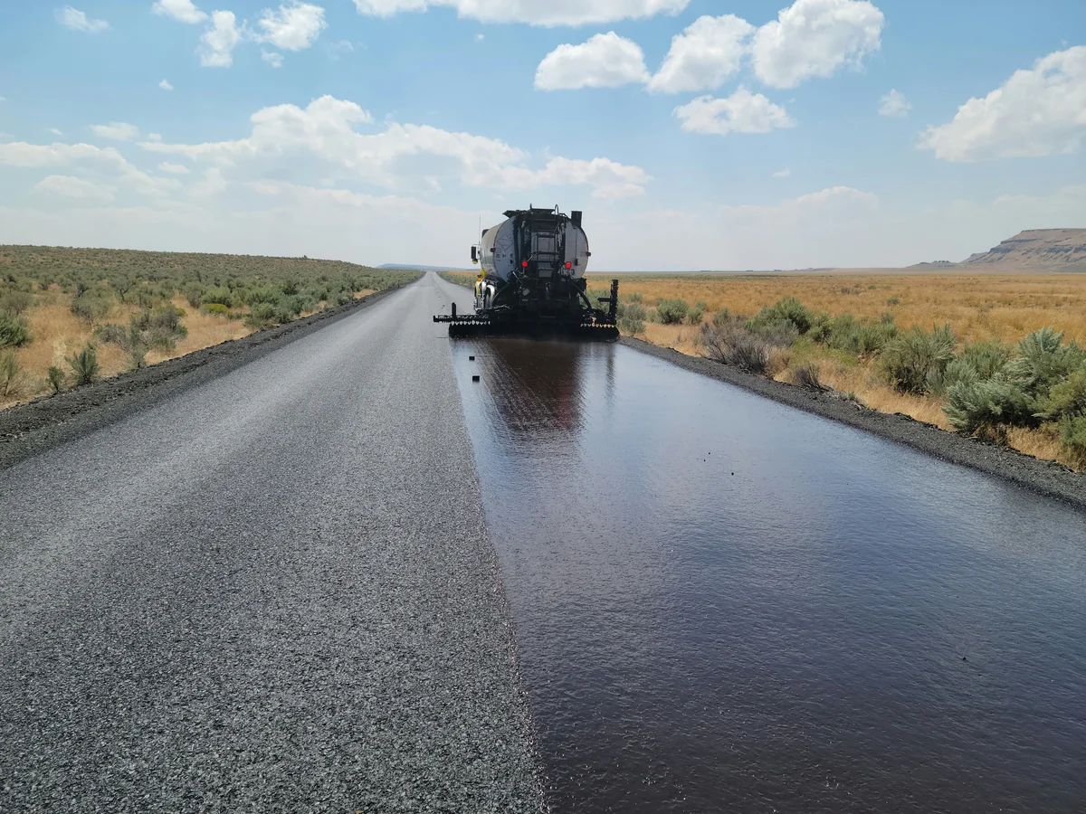 Asphalt paving machine laying fresh black asphalt