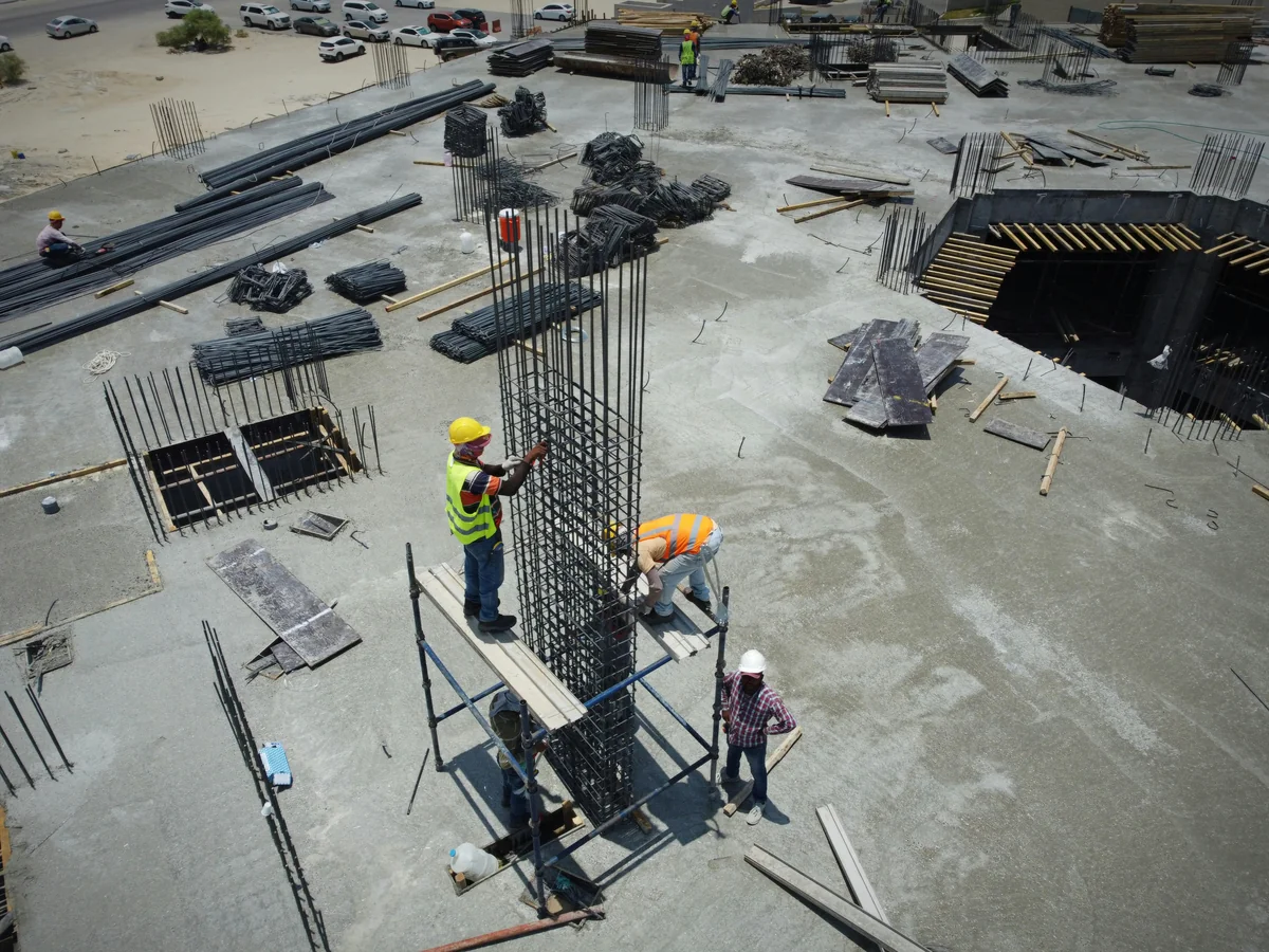 Construction worker pouring wet concrete slab