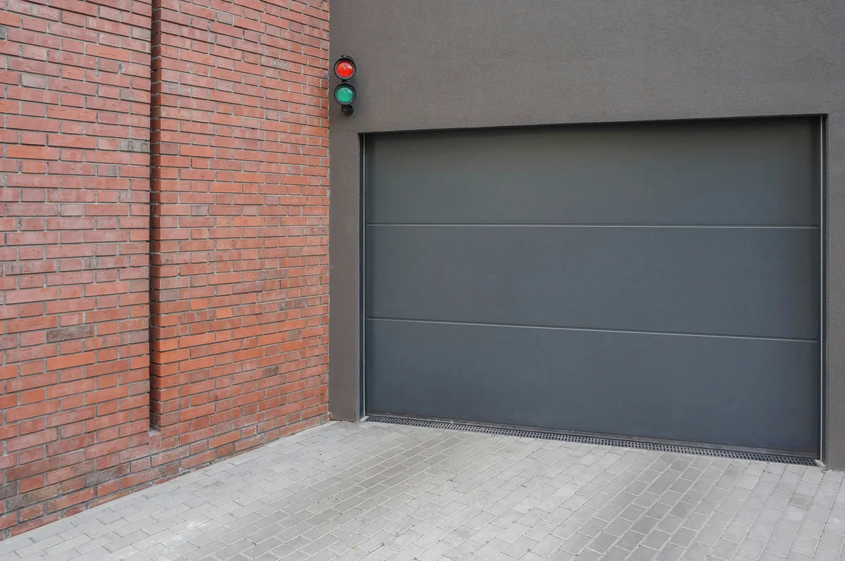 Residential garage door panels on brick wall exterior